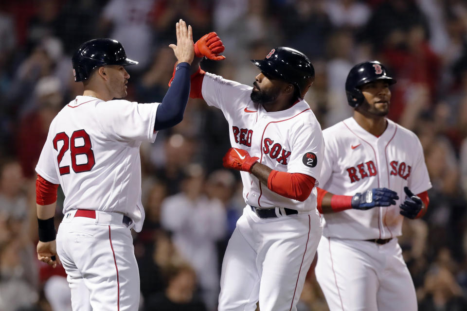 Boston Red Sox's Jackie Bradley Jr., center, celebrates his three-run home run that scored J.D. Martinez (28) and Franchy Cordero, right, during the eighth inning of a baseball game against the Seattle Mariners, Friday, May 20, 2022, in Boston. (AP Photo/Michael Dwyer)
