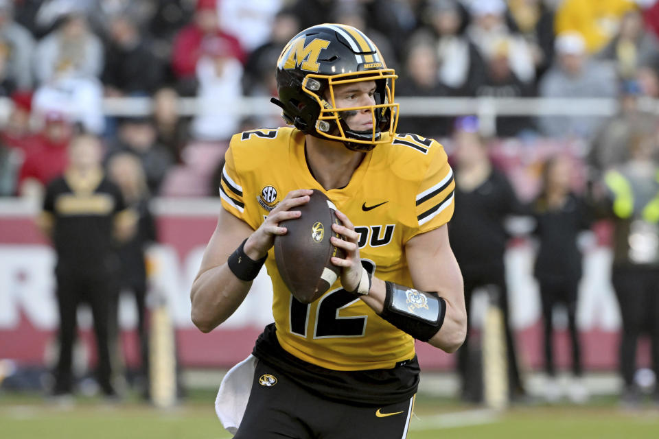 FILE - Missouri quarterback Brady Cook (12) against Arkansas during an NCAA college football game Friday, Nov. 24, 2023, in Fayetteville, Ark. Ninth-ranked Missouri is in its first New Year’s Six game during the four-team College Football Playoff era against seventh-ranked Ohio State in the Cotton Bowl. (AP Photo/Michael Woods, File)