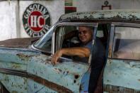 Julio Álvarez, copropietario de Nostalgicar, posa en el interior de su última adquisición de automóvil clásico estadounidense que espera restaurar en La Habana, Cuba, el miércoles 21 de octubre de 2020. (AP Foto/Ramón Espinosa)