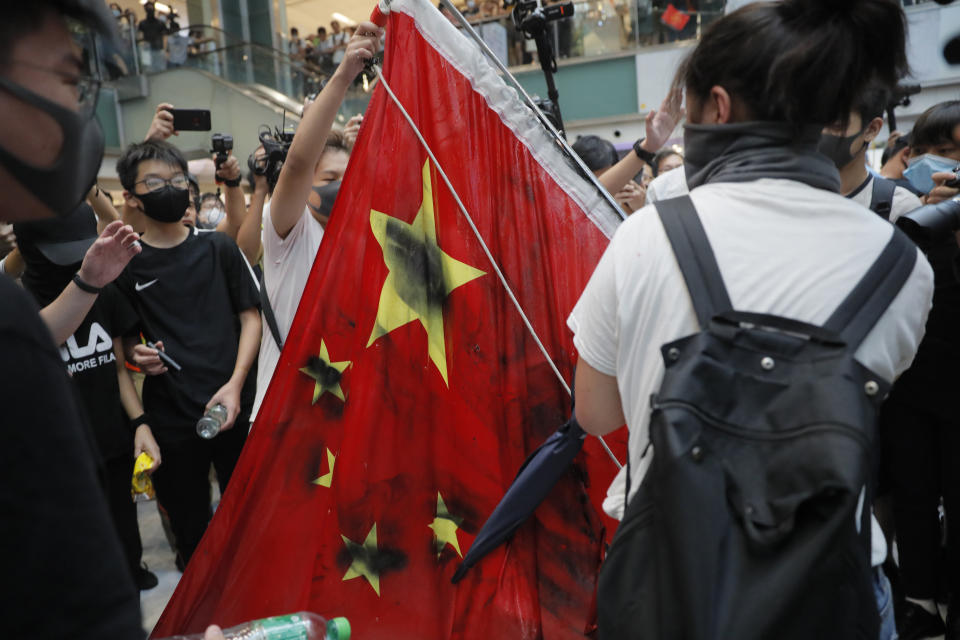 Protesters vandalize a Chinese national flag during a protest at a mall in Hong Kong on Sunday, Sept. 22, 2019. Hong Kong's pro-democracy protests, now in their fourth month, have often descended into violence late in the day and at night. A hardcore group of the protesters says the extreme actions are needed to get the government's attention. (AP Photo/Kin Cheung)