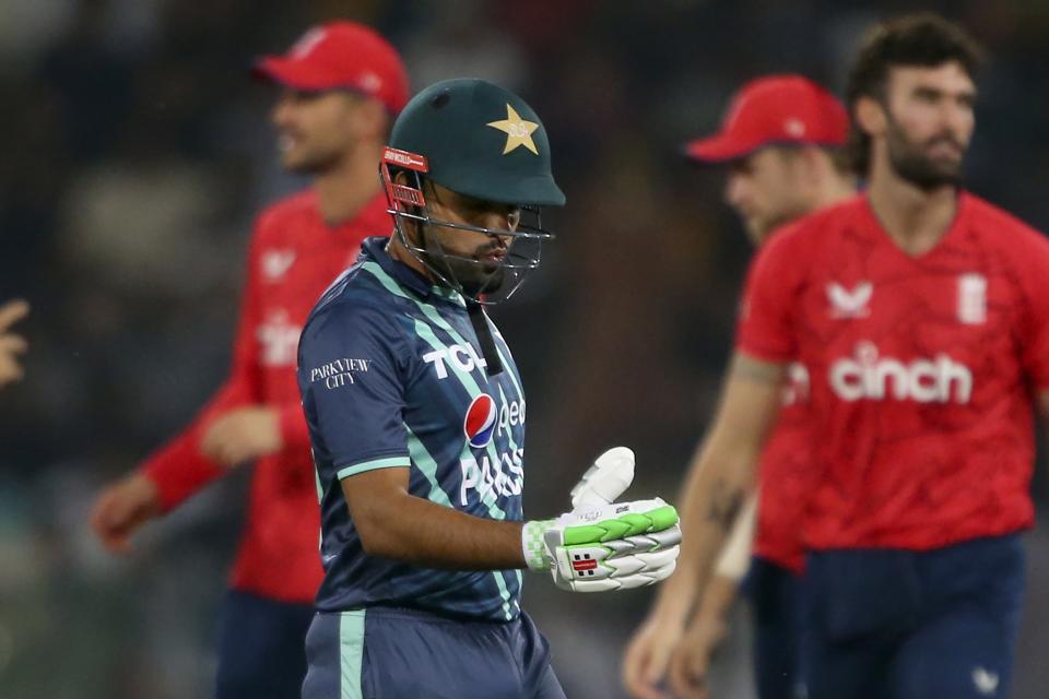 Pakistan's Babar Azam, center, reacts as he walks off the field after losing his wicket during the seventh twenty20 cricket match between Pakistan and England, in Lahore, Pakistan, Sunday, Oct. 2, 2022. (AP Photo/K.M. Chaudary)