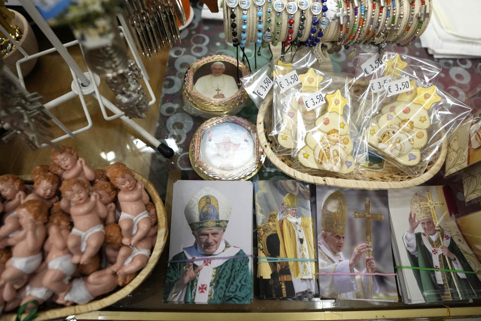 Photos of the late Pope Emeritus Benedict XVI are displayed in a shop in Castel Gandolfo, in the hills south of Rome, Tuesday Jan. 3, 2023. Benedict's death has hit Castel Gandolfo's "castellani" particularly hard, since many knew him personally, and in some ways had already bid him an emotional farewell on Feb. 28, 2013, when he uttered his final words as pope from the palace balcony overlooking the town square. (AP Photo/Alessandra Tarantino)