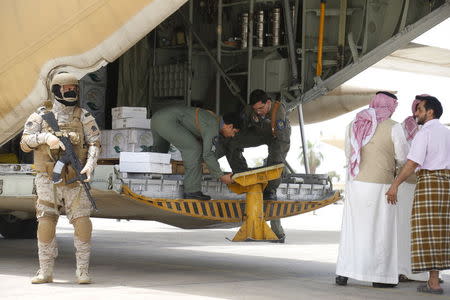 A Saudi soldier stands guard as servicemen on a Saudi military cargo plane prepare to unload aid at the international airport of Yemen's southern port city of Aden July 24, 2015.REUTERS/Faisal Al Nasser