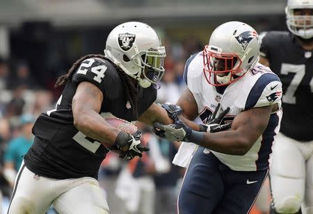 Nov 19, 2017; Mexico City, MEX; Oakland Raiders running back Marshawn Lynch (24) stiff arms New England Patriots linebacker David Harris (45) during an NFL International Series game at Estadio Azteca. The Patriots defeated the Raiders 33-8. Kirby Lee-USA TODAY Sports