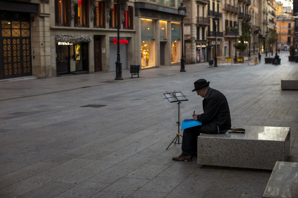 FILE - In this Sunday, March 15, 2020 file photo, a man sits, in an empty street in Barcelona, Spain. The European Union on Tuesday, April 21, 2020 says its vaunted tourism industry is facing decline due to the coronavirus crisis while Internal market Commissioner Thierry Breton says it should be the prime sector to receive over a fifth of all recovery funds. (AP Photo/Emilio Morenatti, File)