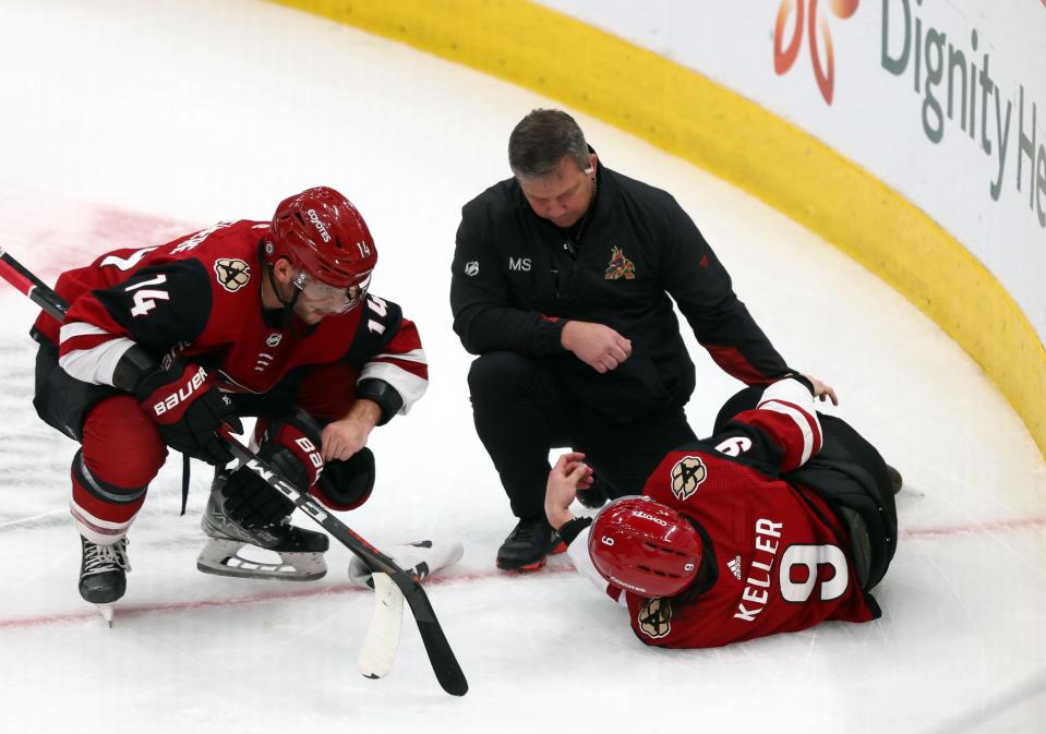 Mar 30, 2022; Glendale, Arizona, USA; Arizona Coyotes trainer comes out to check on Arizona Coyotes right wing Clayton Keller (9) during the third period against the San Jose Sharks at Gila River Arena.