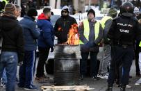 <p>Los policías proceden a desalojar a los taxistas mientras que estos se calientan con un fuego del frío en la capital.<br>Foto: EFE/Víctor Lerena </p>