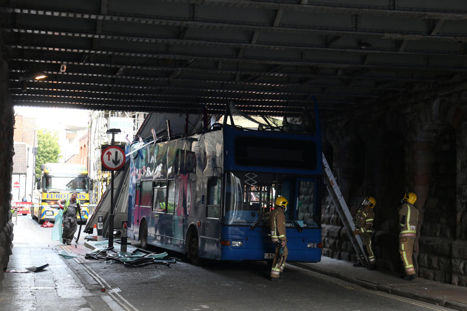 The scene in Bristol where a double decker school bus has driven under a low bridge and ripped its roof off. (SWNS)