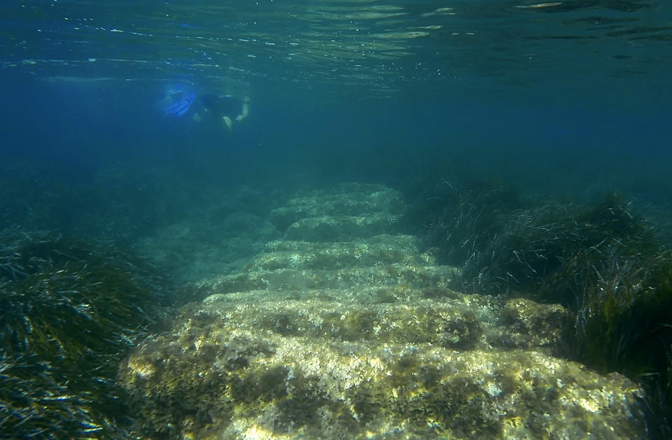 Cyprus Antiquities Department official Yiannis Violaris snorkels over submerged stone remains of the ancient harbor next of Amathus ancient city, in the eastern Mediterranean island of Cyprus, on Thursday, July 1, 2021. Lying just a few feet underwater a mere 200 feet off the coastline near the resort town of Limassol, this 2,400 year-old harbor said to be built Alexander the Great's successors will soon be Cyprus' newest tourist attraction where adventurous holidaymakers could snorkel over its submerged stone remains. (AP Photo/Petros Karadjias)