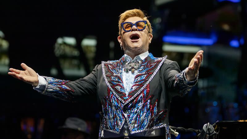 Elton John stands and gestures out at the audience as he performs at Vivint Smart Home Arena in Salt Lake City on Wednesday, Sept. 4, 2019. On Monday night, John won his first Emmy, becoming the 19th person to achieve EGOT status. 