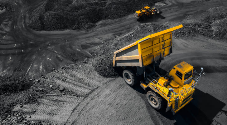 A top aerial view of an open pit mine industry, with a big yellow mining truck for coal
