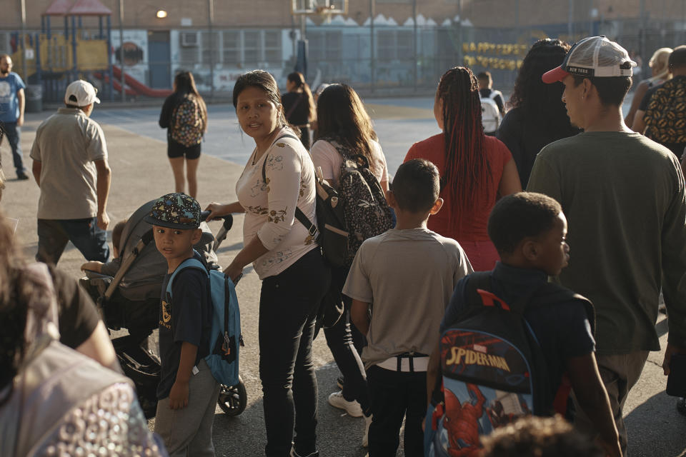 Kimberly Carchipulla, center left, and her son 5 year old Damien Salinas walk into the school on Thursday, Sept. 7, 2023, in New York. Damien attends his first day of school in New York City after his family emigrated from Ecuador in June. Carchipulla and her family have been living in a room at the historic Roosevelt Hotel, converted into a city-run shelter for newly arrived migrant families hoping to find work, a new home and a better life for their children. (AP Photo/Andres Kudacki)