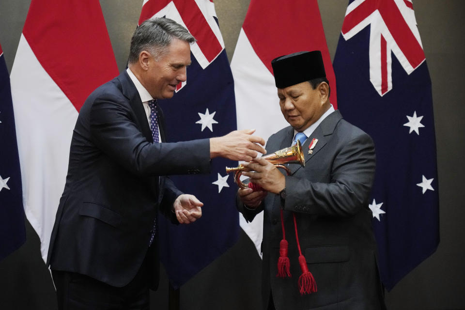 Indonesian Defense Minister Prabowo Subianto, right, receives souvenirs from Australian Deputy Prime Minister and Defense Minister Richard Marles during their meeting in Jakarta, Indonesia, Friday, Feb. 23, 2024. (AP Photo/Achmad Ibrahim)