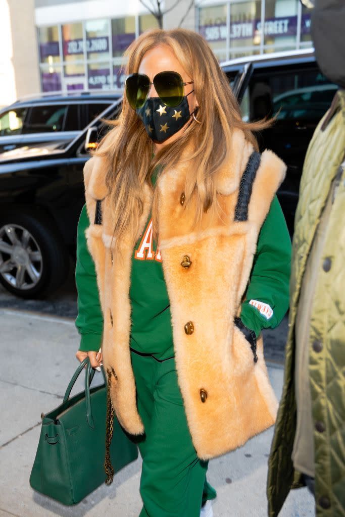 <p>Jennifer Lopez wore a festive-coloured tracksuit while out in in New York City on December 28, ahead of her upcoming performance on Dick Clark’s New Year’s Rockin’ Eve with Ryan Seacrest. </p><p> The singer paired her green athleisurewear with a thick camel-coloured furry vest and a forest-hued Hermès Birkin bag. A star-printed mask and dark green tinted sunglasses finished off the look. </p>