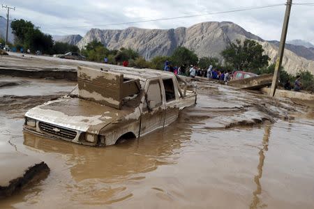 A damaged car covered in mud lies on a street at Copiapo city, March 26, 2015. REUTERS/Ivan Alvarado