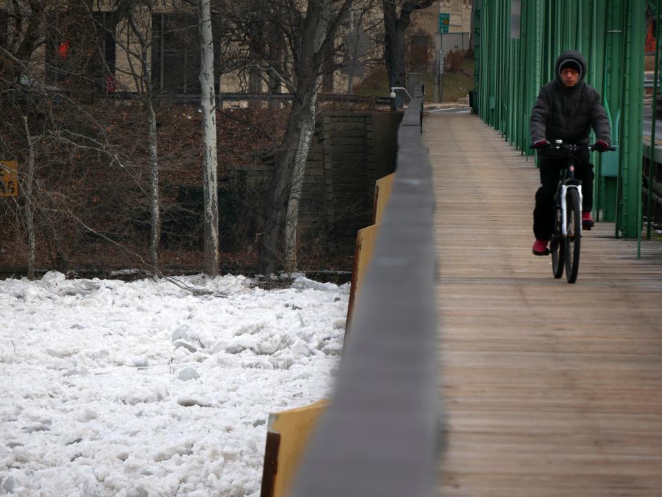 A man bikes over a bridge that spans the partially frozen Delaware River in Trenton, N.J., Tuesday, Jan. 16, 2018.