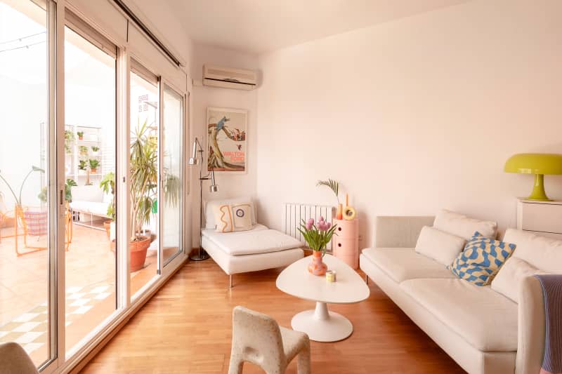 White living room with white sofa, pink accents, large windows