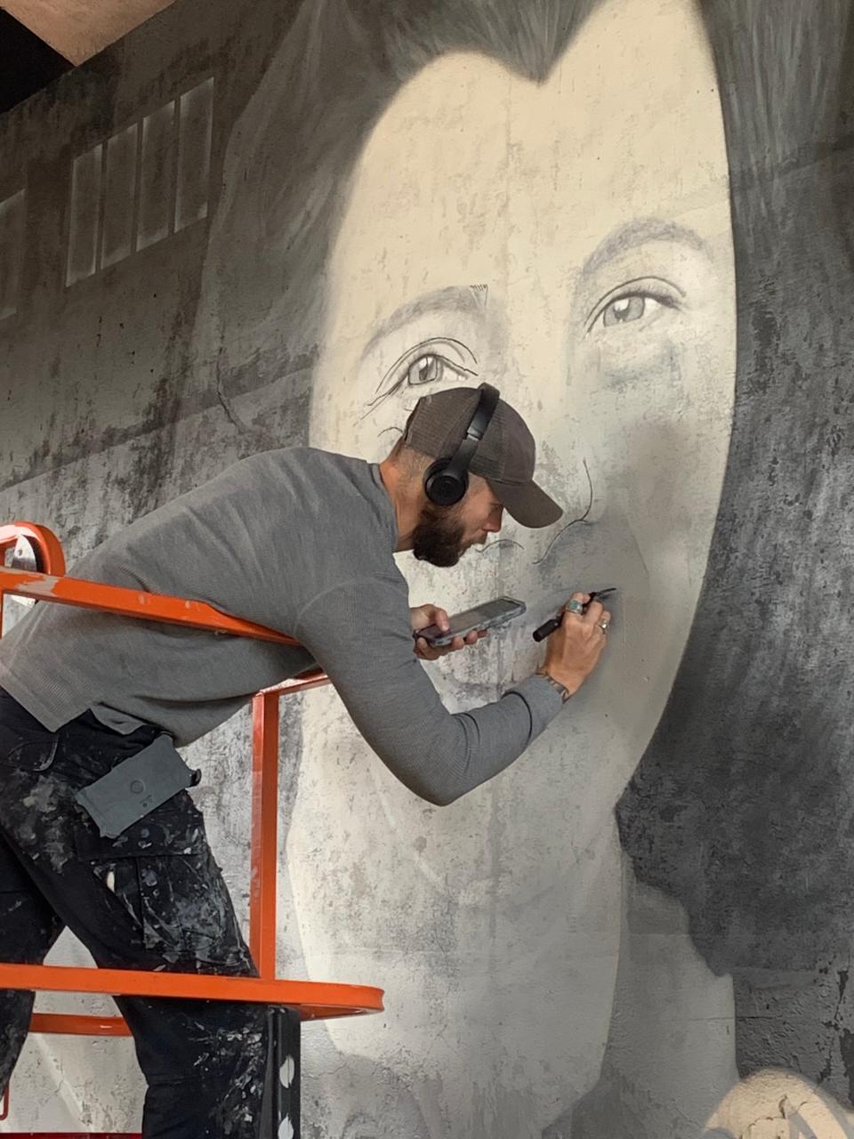 Artist Chris Bomengen continued his work Thursday on a mural beneath the railroad bridge on Timpany Boulevard between Hannaford supermarket and the Route 2 rotary in Gardner.