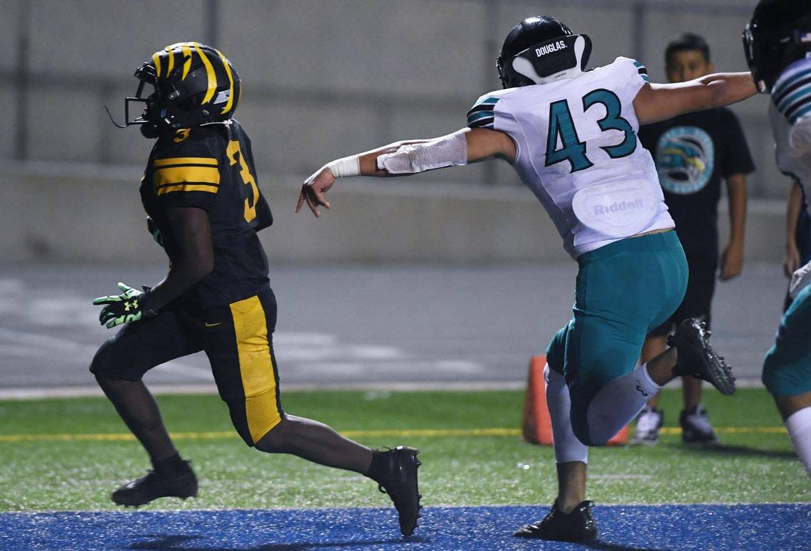 Edison’s Dezjour Malone scores a touchdown with Kennedy’s Sergio Gonzalez III to the right Friday, Aug. 19, 2022, in Fresno. Edison won 20-13.