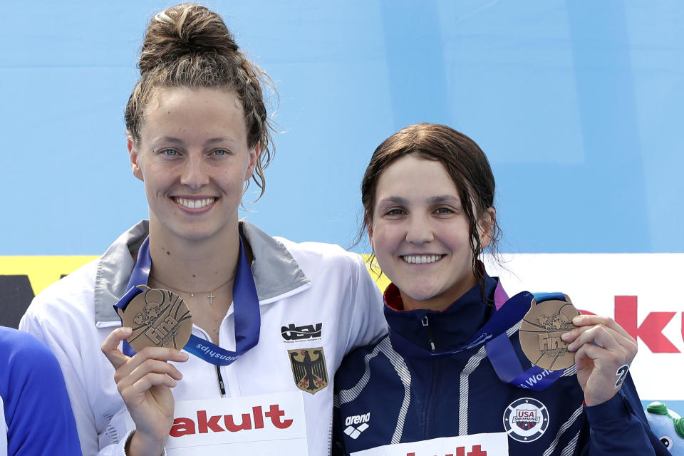 Bronze medalists Leonie Beck of Germany, left, and Hannah Moore of the United States stand with their medals after the women's 5km open water swim at the World Swimming Championships in Yeosu, South Korea, Wednesday, July 17, 2019. (AP Photo/Mark Schiefelbein)