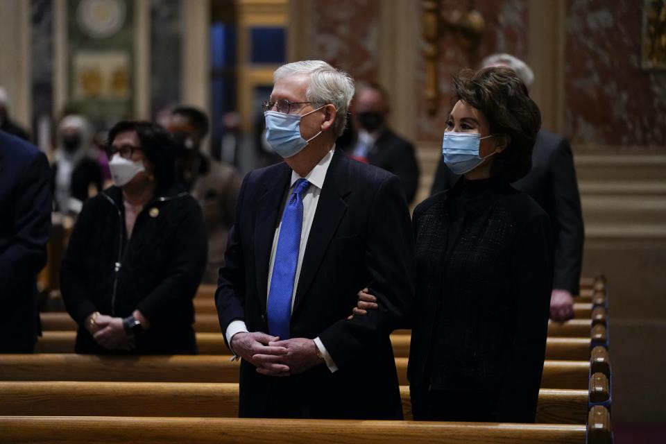 Le leader de la minorité au Sénat Mitch McConnell et sa femme Elaine Chao, masqués, se tiennent derrière un banc d’église