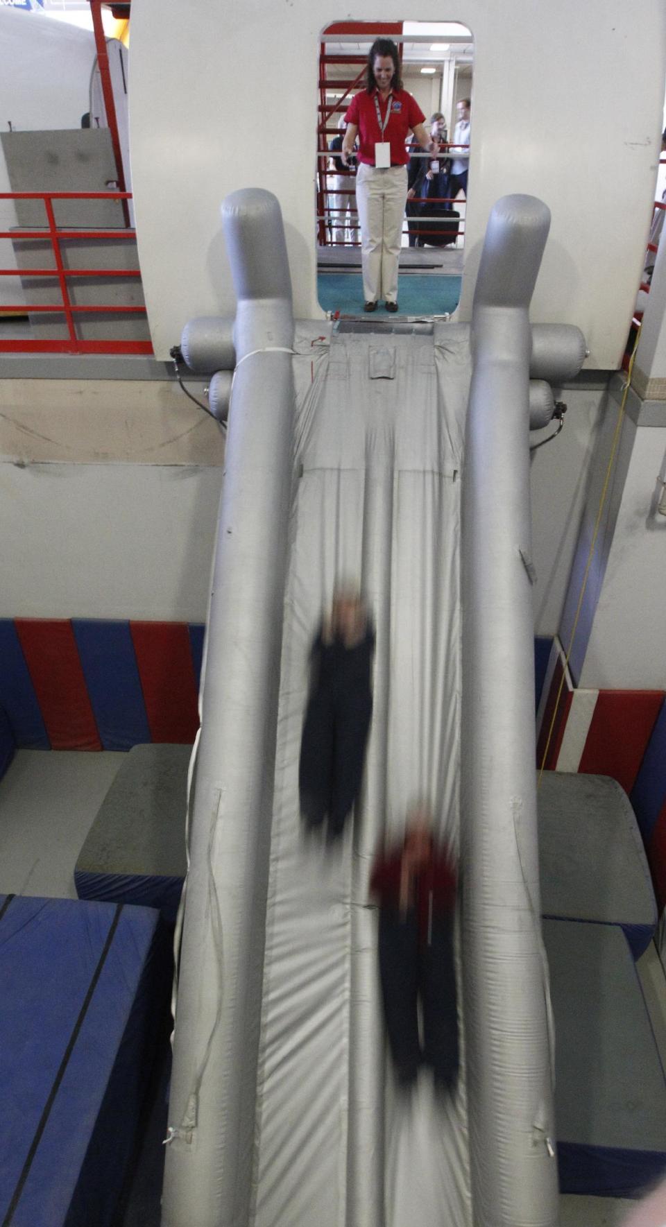 In this photo made Thursday, Jan. 26, 2012, members of the Megado frequent fliers group jump off an emergency exit slide during an exercise at the American Airlines training facility in Fort Worth, Texas. It’s the ultimate field trip for aviation geeks, 160 of frequent fliers chartered an American Airlines jet and hoped across the country visiting aviation industry spots. (AP Photo/LM Otero)