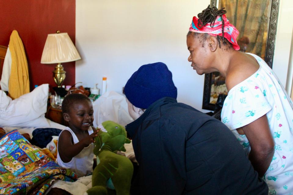 A little boy who lives at the Best Night Inn near New Castle with his grandparents is gleeful to receive a stuffed dinosaur on Thursday, Nov. 2 during an outreach event.