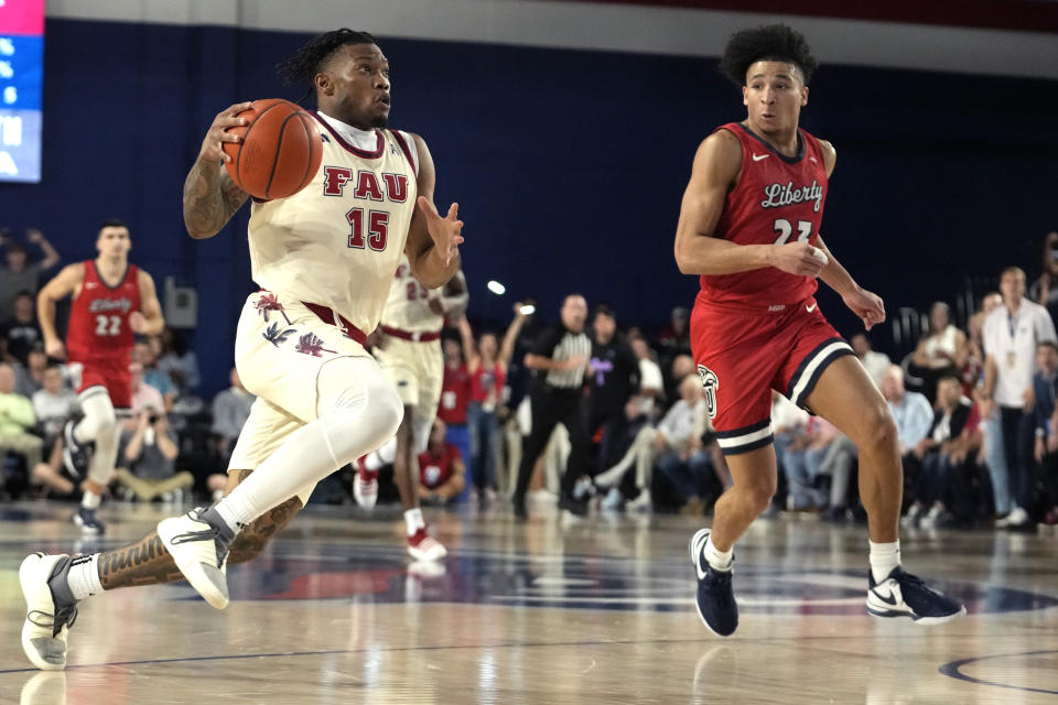 Florida Atlantic guard Alijah Martin (15) drives to the basket as Liberty guard Joseph Venzant, right, defends during the first half of an NCAA college basketball game, Thursday, Nov. 30, 2023, in Boca Raton, Fla. (AP Photo/Lynne Sladky)