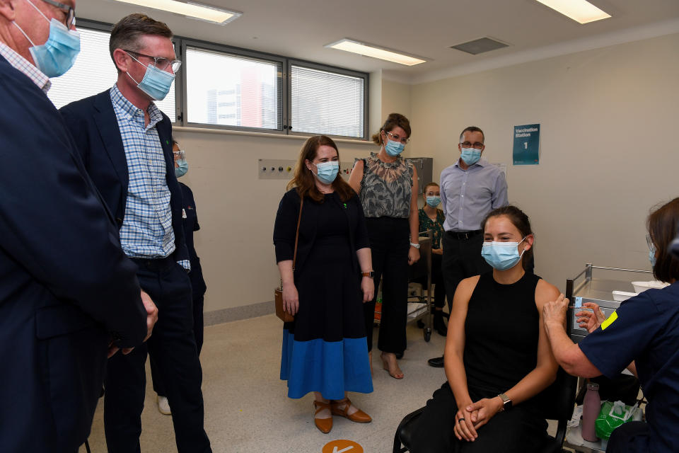 NSW Premier Dominic Perrottet (left) and Hazzard watch on as Rebecca Koerber receives her COVID-19 booster shot. Source: AAP