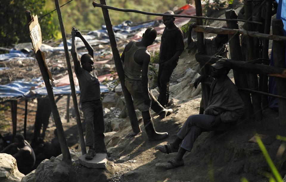 Artisanal miners take a break from panning for gold at the Marco gold mine in Mukungwe locality in Walungu territory of South Kivu May 9, 2014. Decades of corruption, mismanagement and violence have blighted the development of Congo, which at the time of independence in 1960 was Africa's second most industrialised economy. In 2013 it was near the foot of global tables for per capita economic output. Now industrial mining operations are moving back to regions that have been the preserve of artisanal miners since the collapse of Congo's state-run mining operations in the 1990s, at the end of dictator Mobutu Sese Seko's 31-year rule. Picture taken May 9, 2014. REUTERS/Kenny Katombe (DEMOCRATIC REPUBLIC OF CONGO - Tags: BUSINESS EMPLOYMENT COMMODITIES INDUSTRIAL CIVIL UNREST POLITICS)