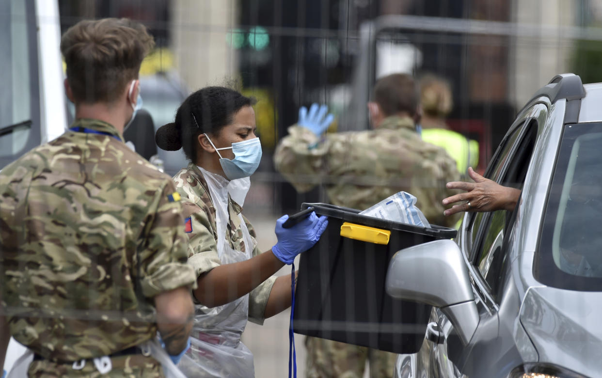 Members of the army work at a coronavirus testing station set up in Victoria Park in Leicester, England, Tuesday June 30, 2020. The British government has reimposed lockdown restrictions in the English city of Leicester after a spike in coronavirus infections, including the closure of shops that don't sell essential goods and schools. (AP Photo/Rui Vieira)