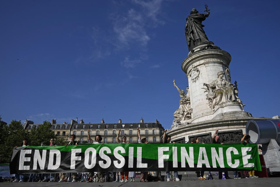 Climate activists stage a protest in the Place de la Republique on the sidelines of the Global Climate Finance Summit in Paris, Friday, June 23, 2023. World leaders, heads of international organizations and activists are gathering in Paris for a two-day summit aimed at seeking better responses to tackle poverty and climate change issues by reshaping the global financial system. (AP Photo/Michel Euler)