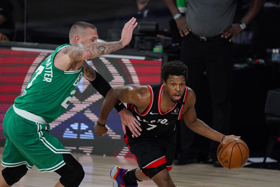 Toronto Raptors guard Kyle Lowry (7) dribble away from Boston Celtics center Daniel Theis (27) during the first half of an NBA conference semifinal playoff basketball game Wednesday, Sept. 9, 2020, in Lake Buena Vista, Fla. (AP Photo/Mark J. Terrill)