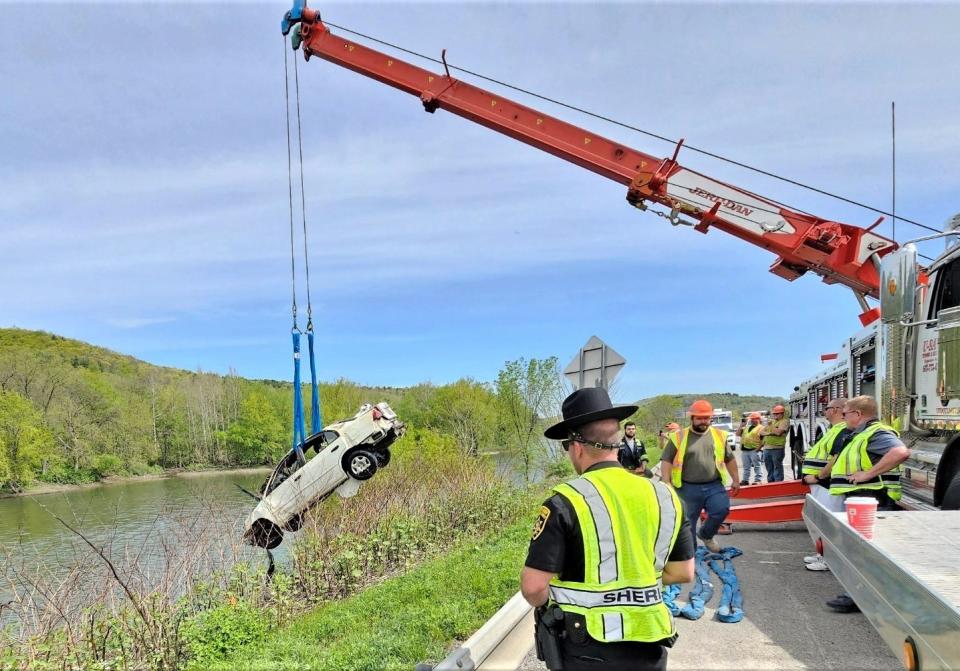 A Broome County sheriff's deputy watches as a vehicle involved in a May 5 crash is recovered from the Chenango River in the Town of Fenton on Saturday, May 13, 2023.