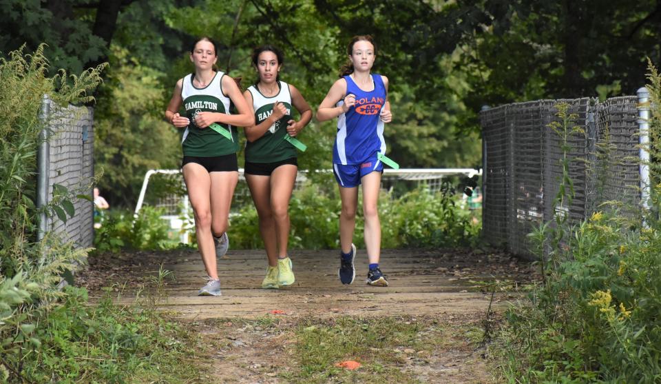 Runners from Hamilton and Poland cross a bridge on Poland's cross country course during Wednesday's Center State Conference dual meet in Poland.
