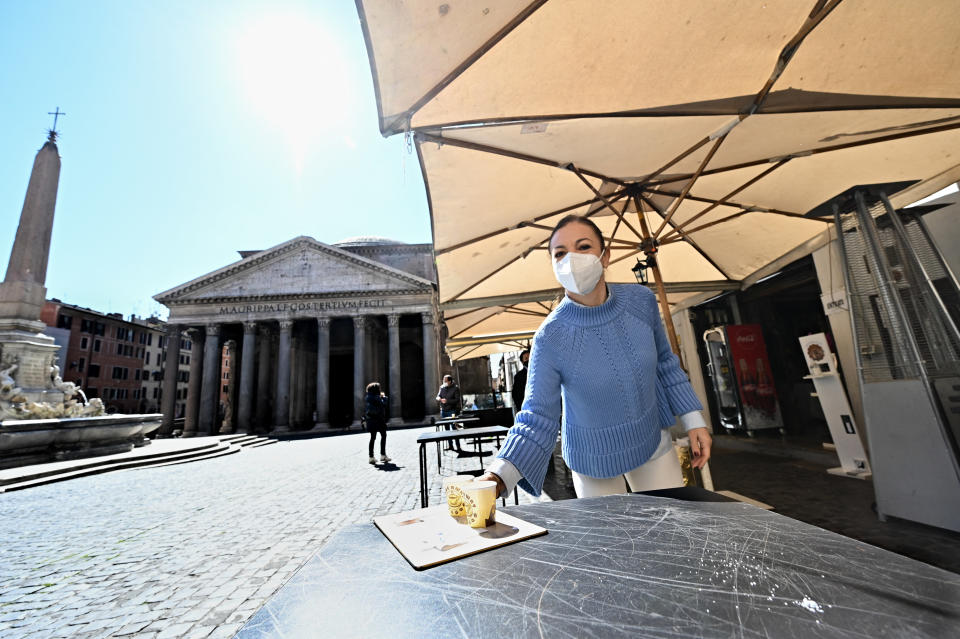 Staff of a coffe-restaurant, brings coffees for customers, in Piazza della Rotonda at the Pantheon, in central Rome, on March 15, 2021, as three-quarters of Italians entered a strict lockdown as the government put in place restrictive measures to fight the rise of COVID-19 infections. (Photo by Andreas SOLARO / AFP) (Photo by ANDREAS SOLARO/AFP via Getty Images)