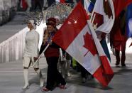 Canada's flag-bearer Kaillie Humphries (front R) enters the arena during the closing ceremony for the 2014 Sochi Winter Olympics, February 23, 2014. REUTERS/Phil Noble (RUSSIA - Tags: OLYMPICS SPORT)