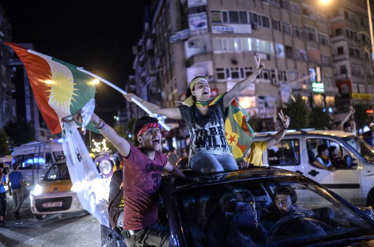 Supporters of pro-Kurdish Peoples' Democratic Party hold Kurdish flags as they celebrate the results of the legislative election, in Diyarbakir on June 7, 2015