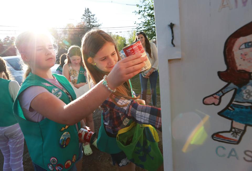 Raynham Junior Girl Scout Troop 82256 members Addison Pellerin and Casey Mulcahystock the new Little Free Pantry at Johnson's Pond in Raynham on Thursday, May 12, 2022. The Little Free Pantry is located right next to the local Cub Scout's Little Free Library.  
