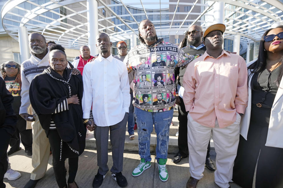 Michael Corey Jenkins, third from left, and Eddie Terrell Parker, right, stand with supporters outside the courthouse in Jackson, Miss., Tuesday, March 19, 2024, calling for harsh penalties against six former law enforcement officers who committed numerous acts of racially motivated, violent torture on himself and his friend Eddie Terrell Parker in 2023. The six former law officers pleaded guilty to a number of charges for torturing them and sentencing begins Tuesday in federal court. (AP Photo/Rogelio V. Solis)
