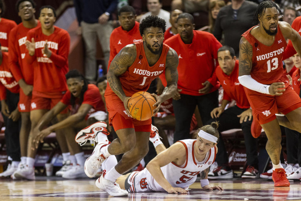 Houston's Jamal Shead (1) dribbles against the defense of Utah's Gabe Madsen, bottom, in the first half of an NCAA college basketball game during the Charleston Classic in Charleston, S.C., Friday, Nov. 17, 2023. (AP Photo/Mic Smith).