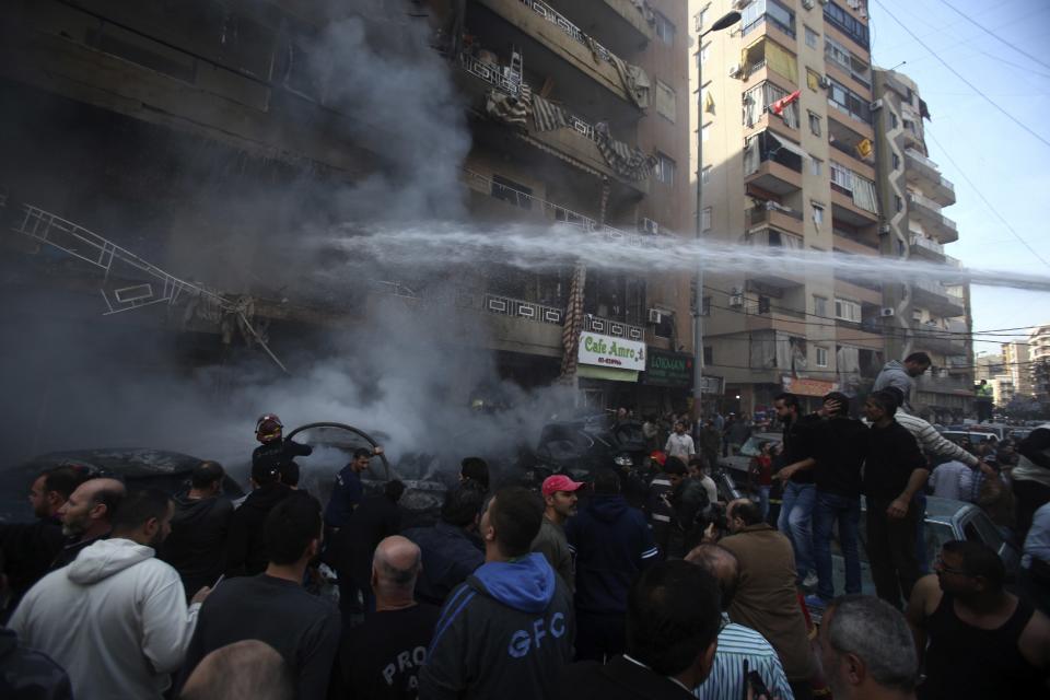 Firefighters extinguish a fire from a building at the site of an explosion in the Haret Hreik area, in the southern suburbs of the Lebanese capital Beirut