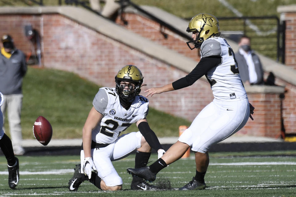 Vanderbilt's Sarah Fuller, right, kicks off as Ryan McCord (27) holds to start the second half of an NCAA college football game against Missouri Saturday, Nov. 28, 2020, in Columbia, Mo. With the kick, Fuller became the first female to play in a Southeastern Conference football game. (AP Photo/L.G. Patterson)