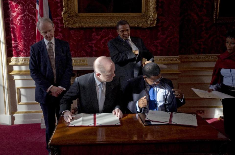 Britain's Foreign Secretary William Hague, seated left, and Tanzania's Minister for Foreign Affairs and International Co-operation Bernard Membe, seated right, prepare to sign a treaty on dealing with piracy off the coast of Somalia, watched by Tanzania's President Jakaya Kikwete, standing center, and Britain's Under-Secretary of State at the Foreign and Commonwealth Office Henry Bellingham, standing left, during the London Conference on Somalia at Lancaster House in London, Thursday, Feb. 23, 2012. Nations must help Somalia's fragile leadership tackle terrorism, piracy and hunger or be prepared to pay the price, Britain's leader warned Thursday at an international conference on the troubled east African nation's future. About 50 nations and international organizations attended a one-day summit hosted by Prime Minister David Cameron in London, including Somalia's Western-backed transitional government, U.S. Secretary of State Hillary Rodham Clinton and United Nations Secretary-General Ban Ki-moon. (AP Photo/Matt Dunham-Pool)