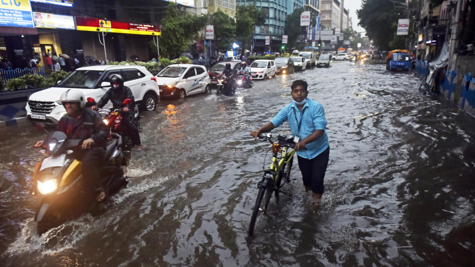 A man wades through a flooded street with his bicycle after a heavy rainfall in Kolkata, India, in July.