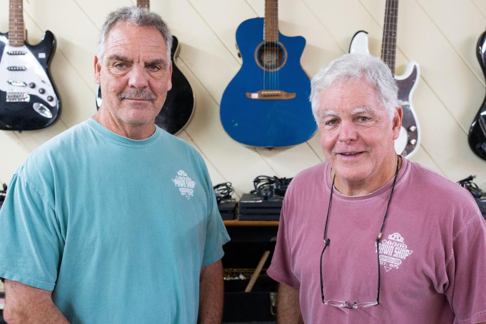 Brothers and owners of Mike’s Pawn Shop, Mark Norman and Mike Norman Jr. pose for a portrait in their store Thursday, July 20, 2023.