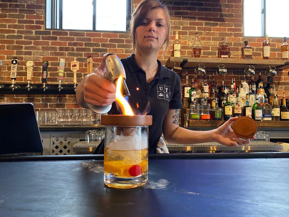 Kiara B. Jacobs, a server at the brand new Union Straw restaurant in Taunton, makes a smoked Mezcal old-fashioned on Friday, Jan. 19, 2024.