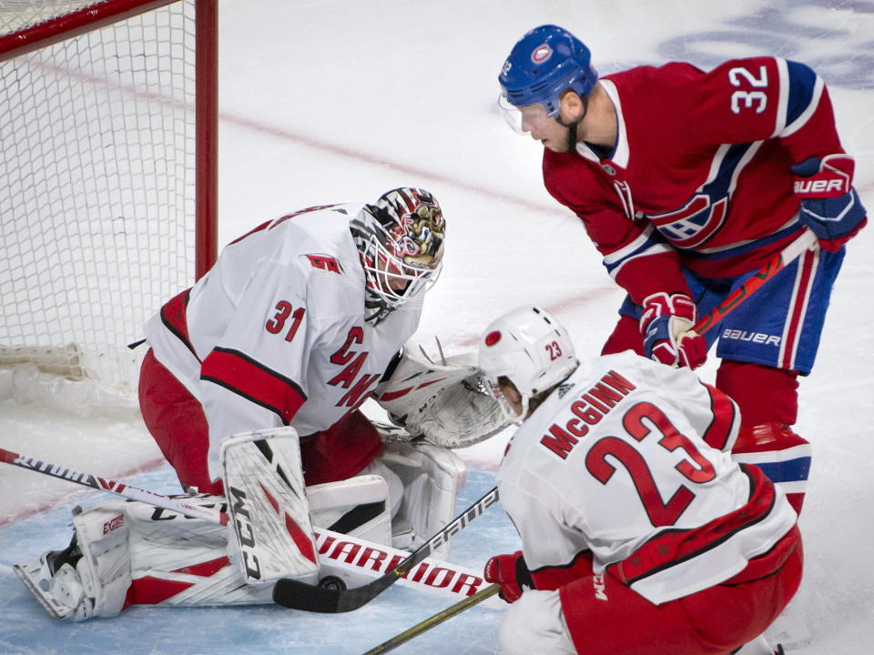 Carolina Hurricanes goaltender Anton Forsberg (31) puts the stop on Montreal Canadiens defenseman Christian Folin (32) as Hurricanes left wing Brock McGinn (23) watches during the first period of an NHL hockey game Saturday, Feb. 29, 2020, in Montreal. (Peter McCabe/The Canadian Press via AP)