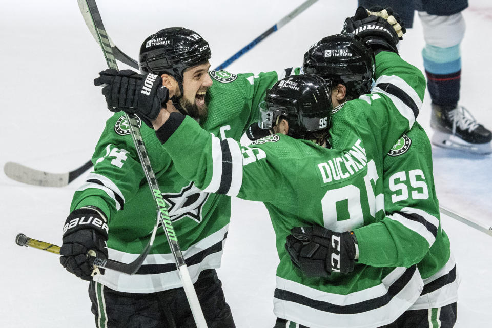 Dallas Stars left wing Jamie Benn, left, celebrates with center Matt Duchene (95) and defenseman Thomas Harley (55) after Harley scored the game-winning goal during overtime of an NHL hockey game against the Seattle Kraken Monday, Dec. 18, 2023, in Dallas. (AP Photo/Jeffrey McWhorter)