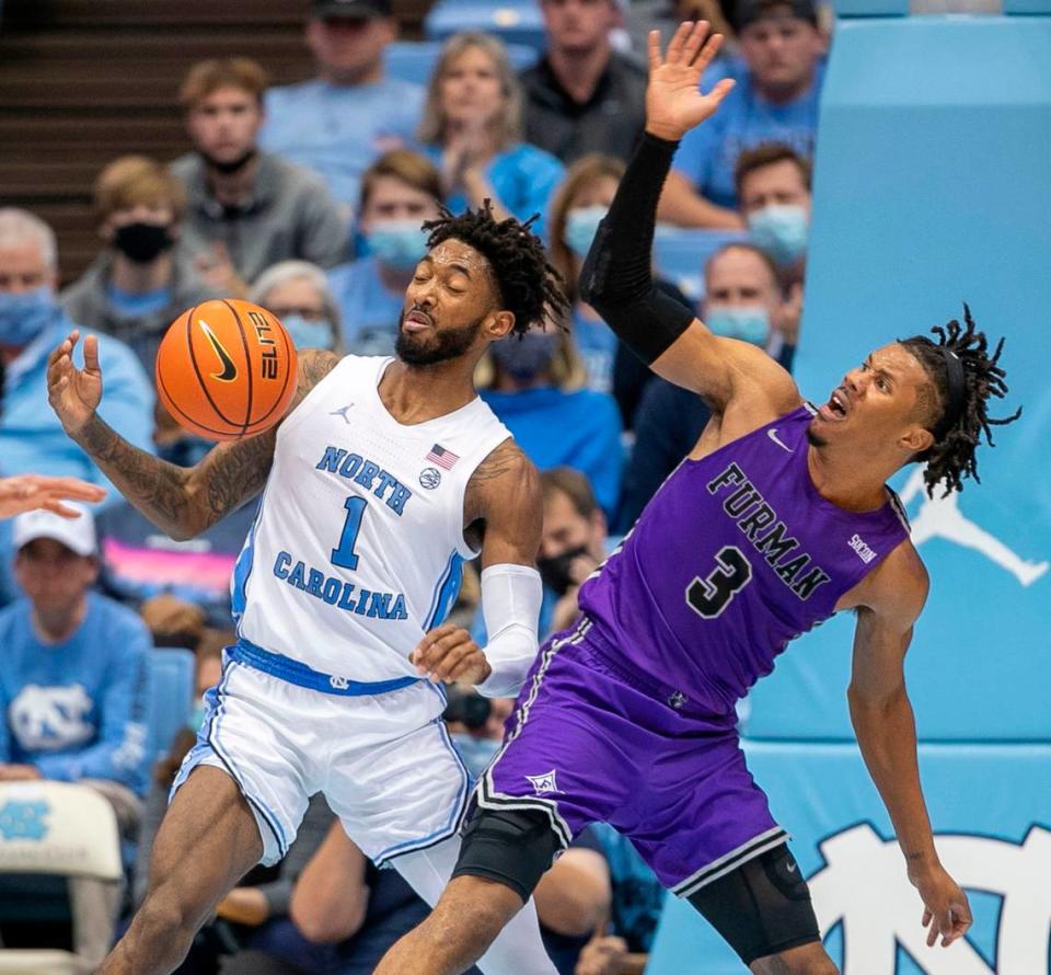 North Carolina’s Leaky Black (1) and Furman’s Mike Bothwell (3) battle for a loose ball during the second half on Tuesday, December 14, 2021 at the Smith Center in Chapel Hill, N.C.